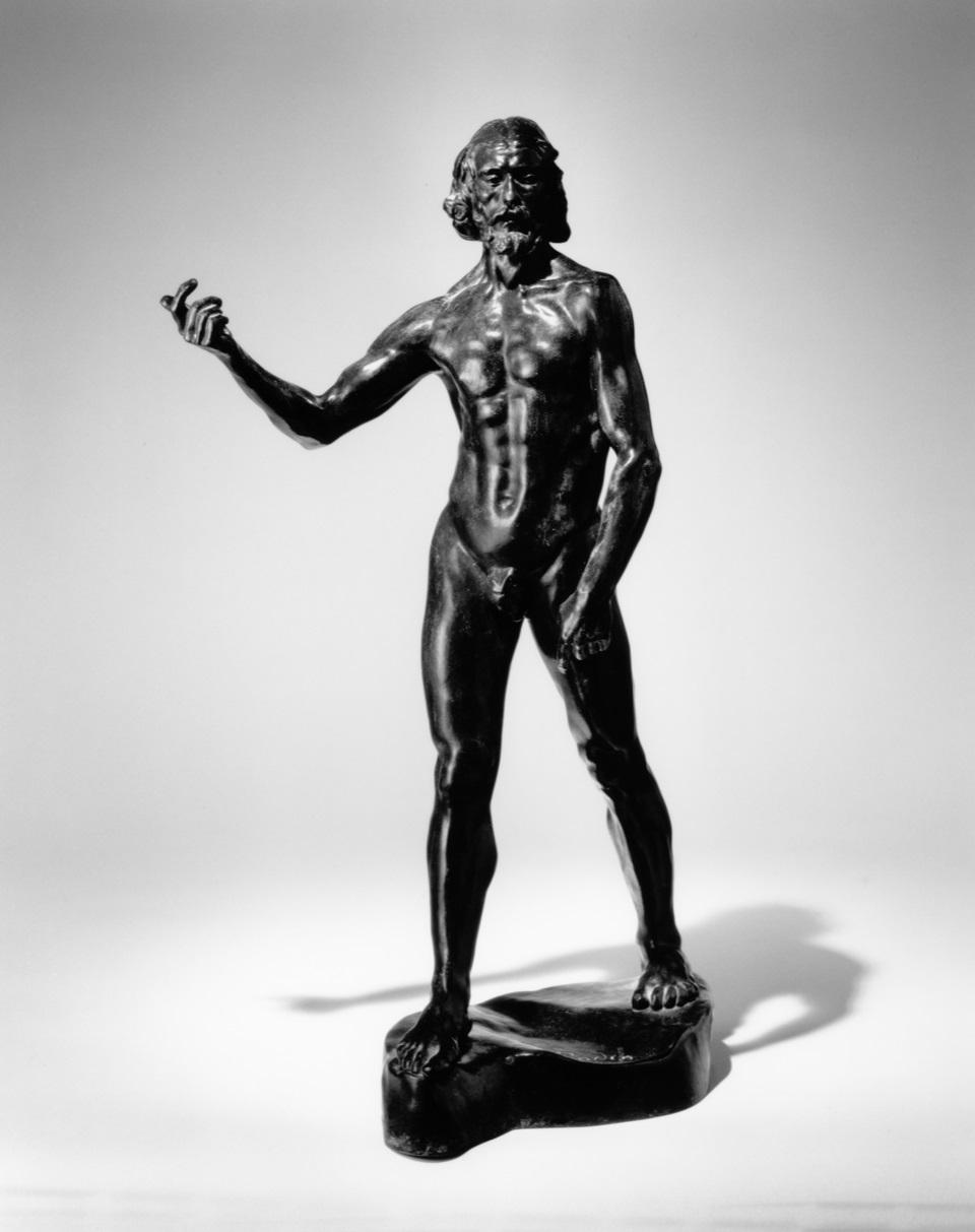 Black and white image of a bronze sculpture of St. John the Baptist. He is naked and striding forward with his right arm extended out.