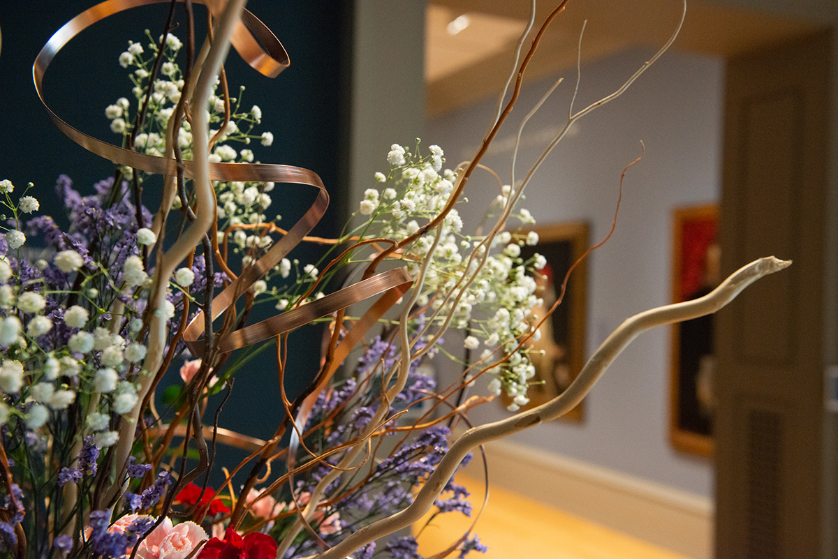A flower arrangement in front of the entrance to a gallery