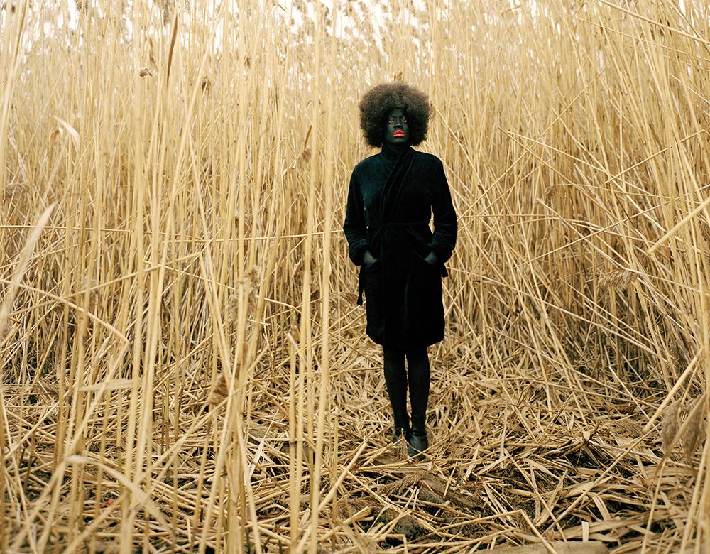 Woman in blackface standing in a wheat field