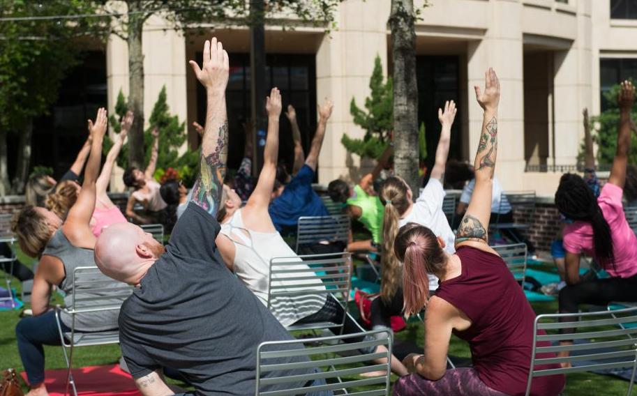 Photo of men and women performing yoga outside of the CMA