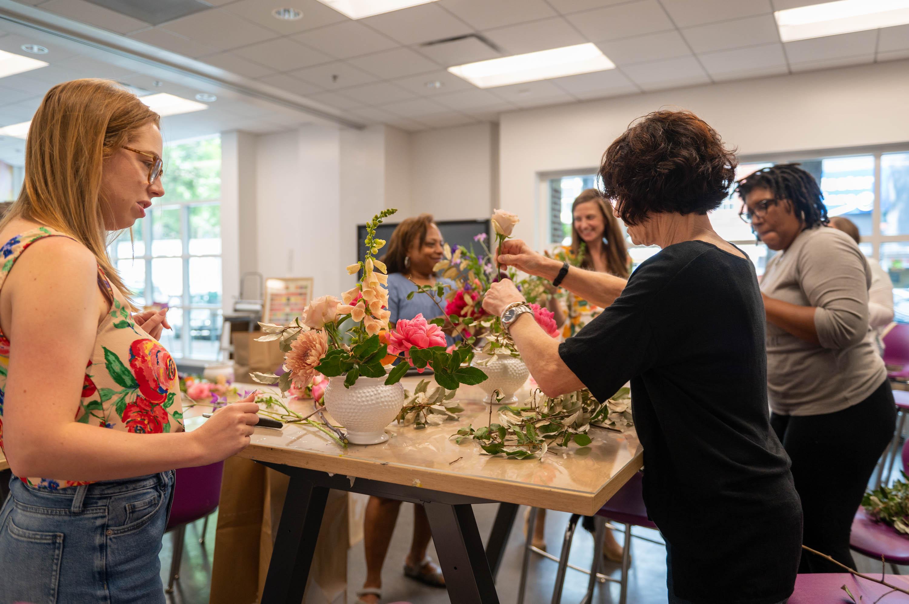 Group of diversed women working on floral design arrangements 