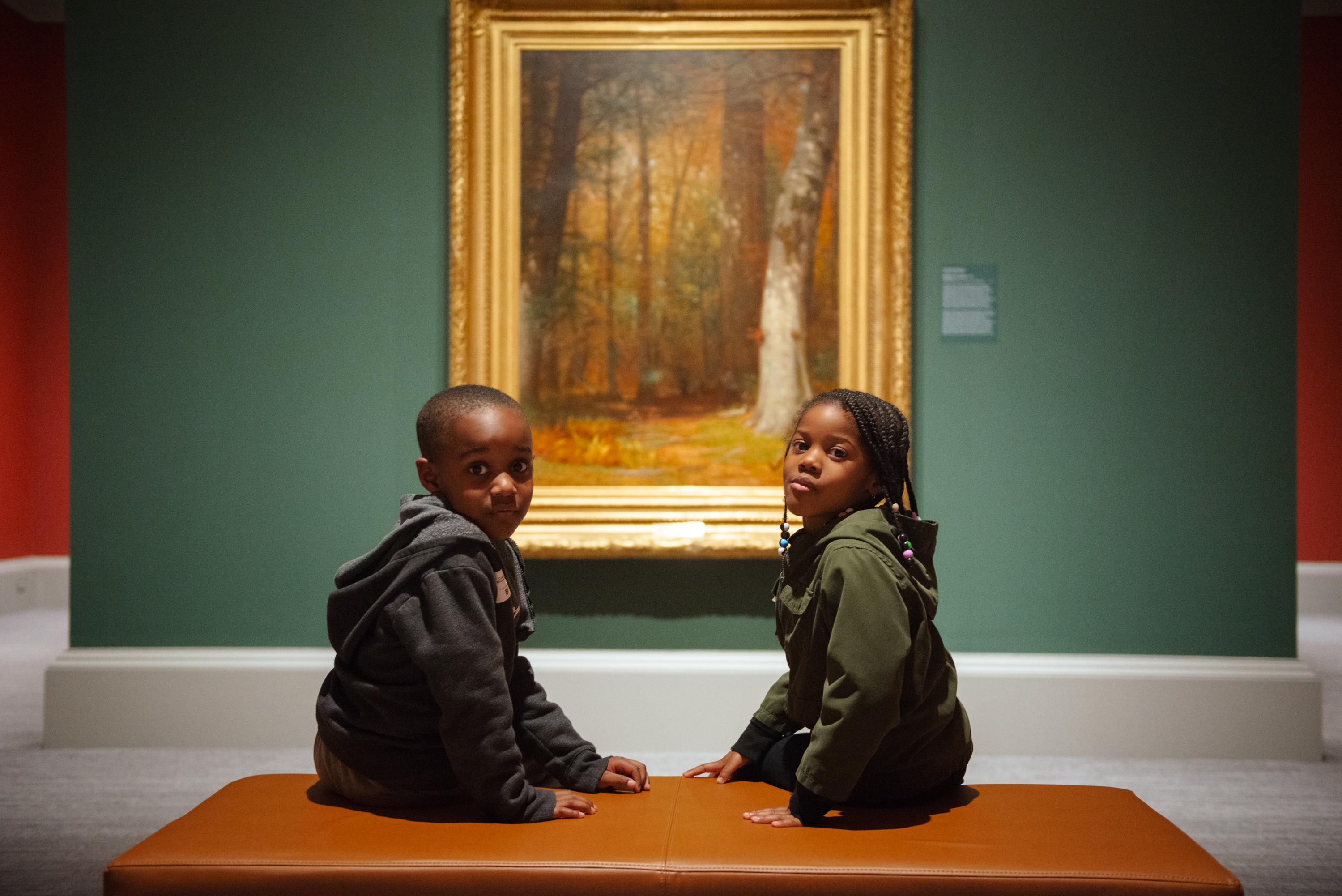 Two children of color in front of nature in fall season painting
