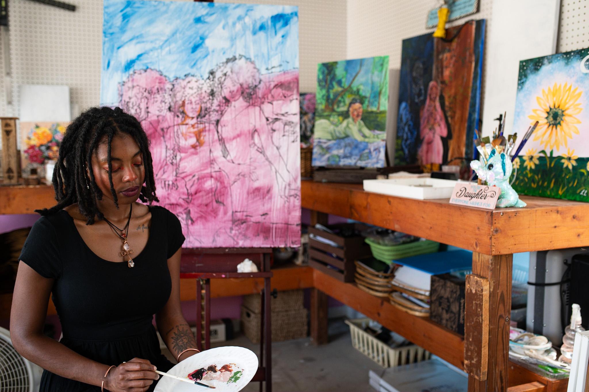 Instructor LaLa Cann in her studio holding brush and paint 