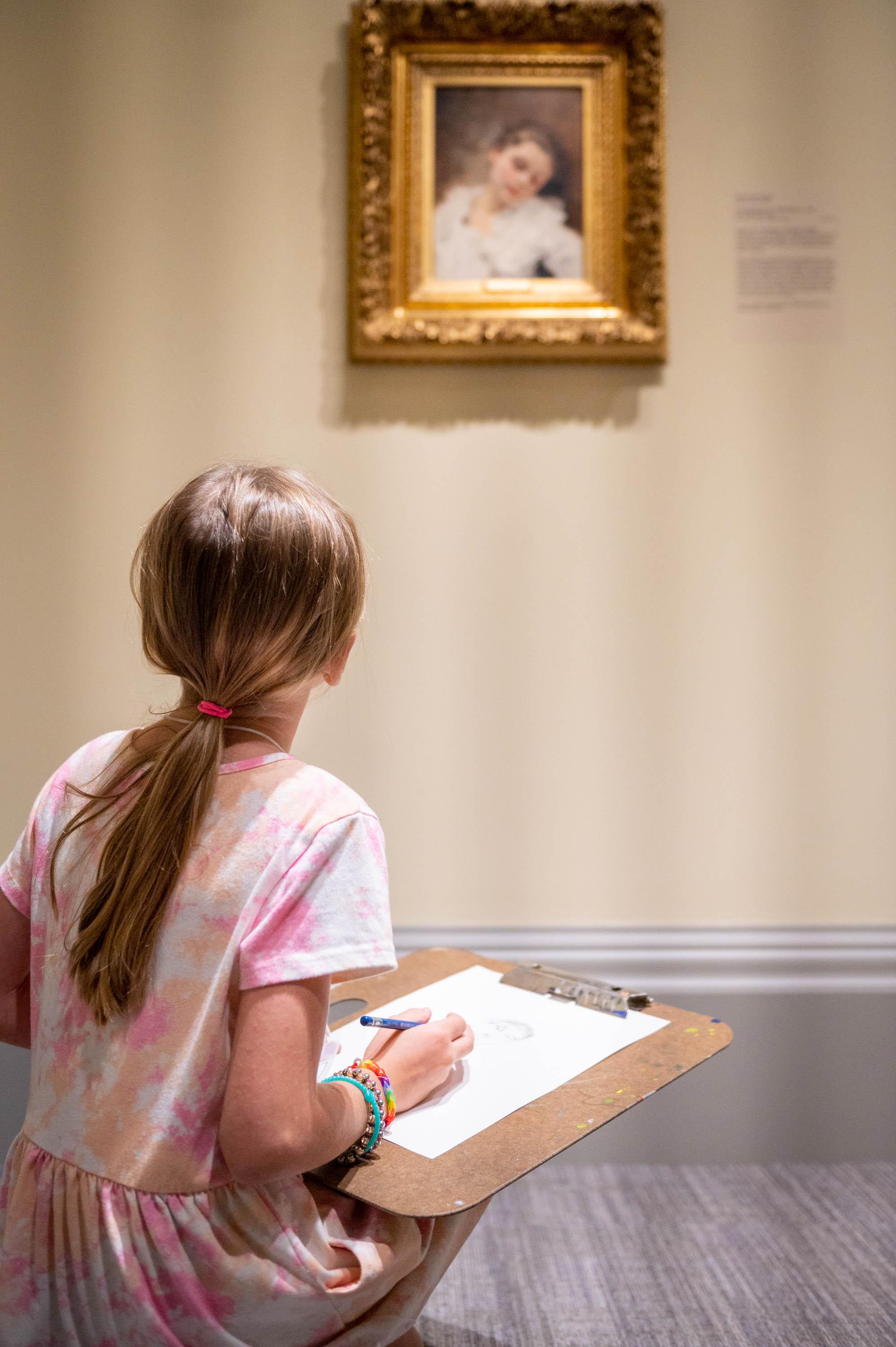 a child sketching from a portrait in the galleries