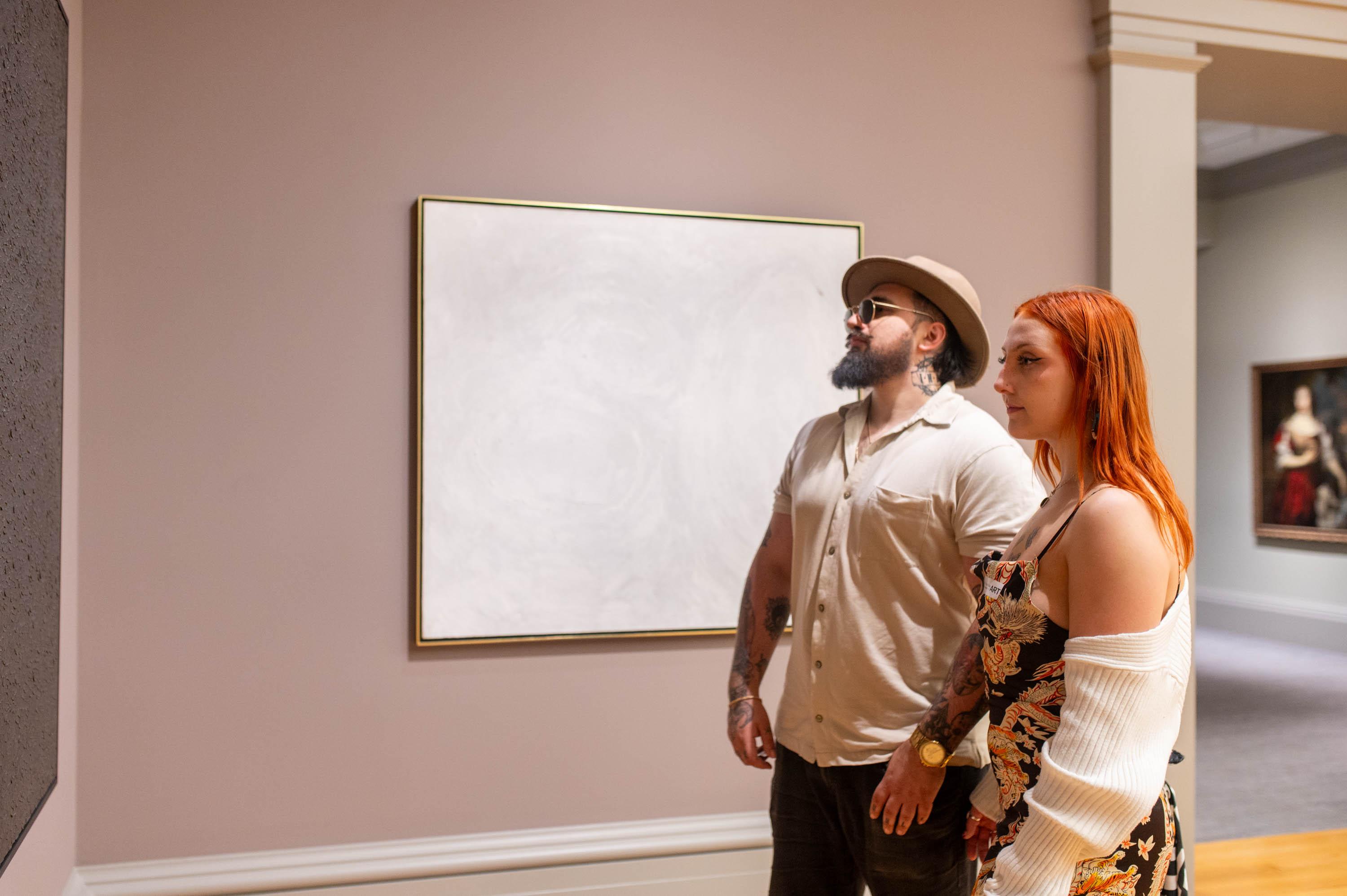 two young people looking at art in the gallery
