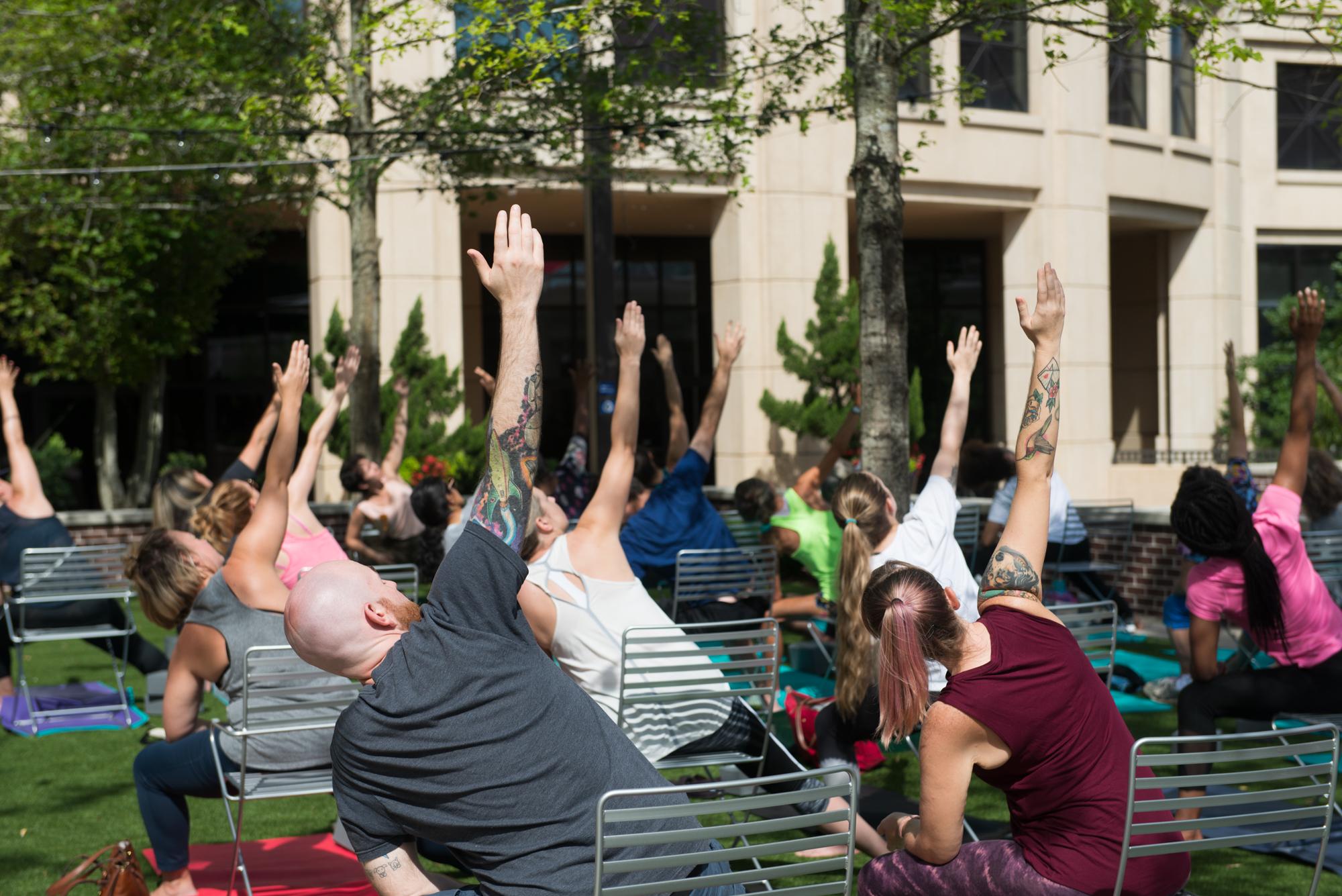 students participating in yoga while seated in chairs