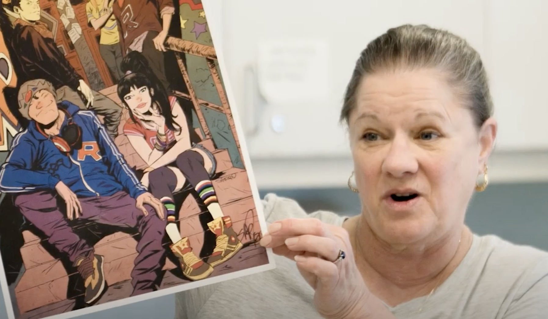 Mary Hendrix hold up an example piece of art while talking to a class