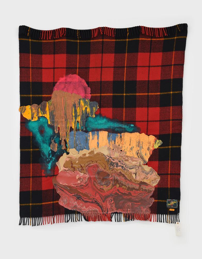 a plaid blanket with paint covering much of it