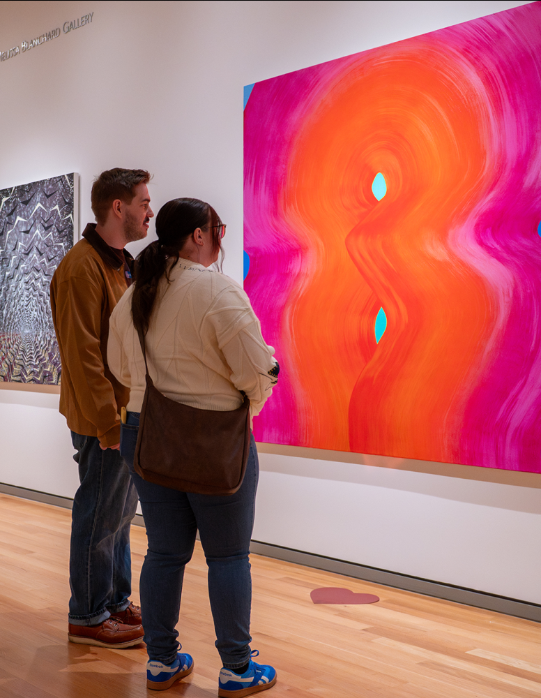 visitors viewing a brightly colored abstract painting